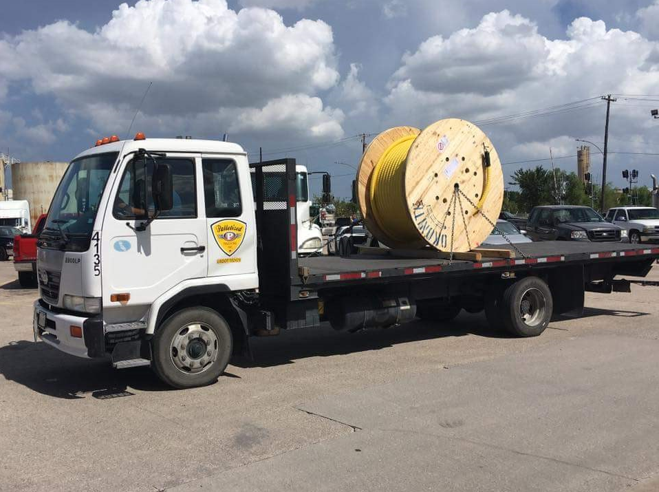 Palletized hot shot straight truck hauling large cable spool on flatbed