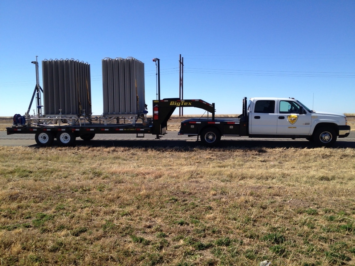 Hot shot truck pulling Big Tex gooseneck trailer loaded with industrial tanks